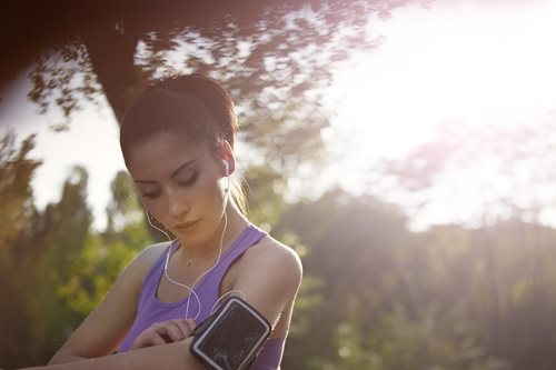 young-sportswoman-listening-to-music-in-park-3776837-(1).jpg